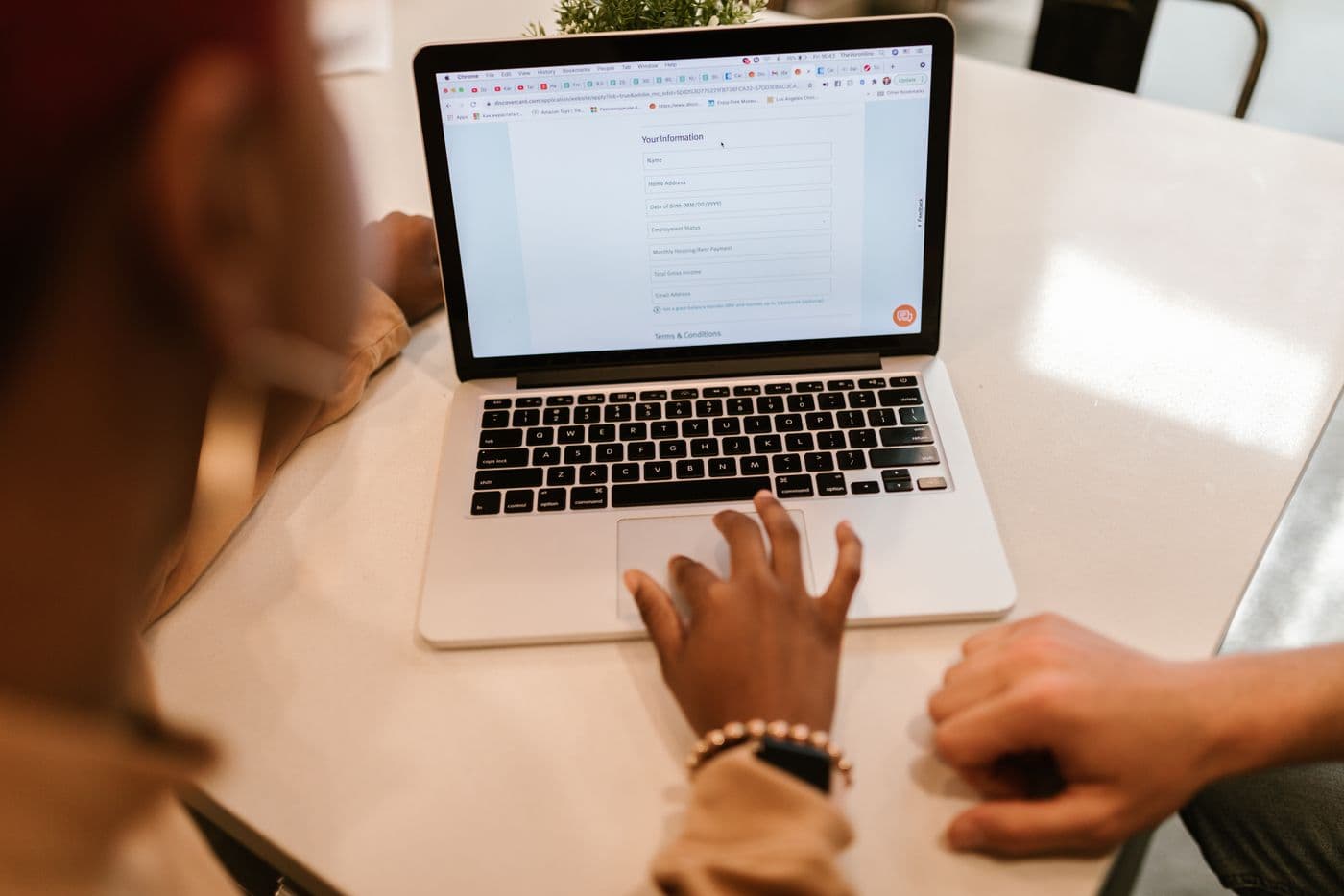 A person completing a form on a laptop